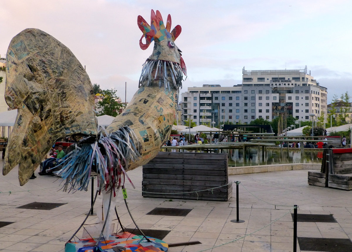 Praca Martim Moniz mit der nicht zu übersehenden Skulptur eines Huhns, die zum Teil aus Zeitungen besteht. Im Hintergrund das Hotel Mundial, unsere Unterkunft